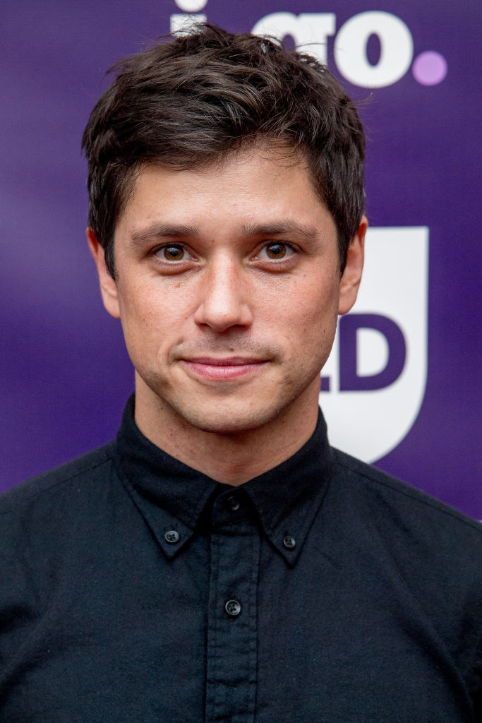 Raviv as an adult in a button up shirt on the red carpet