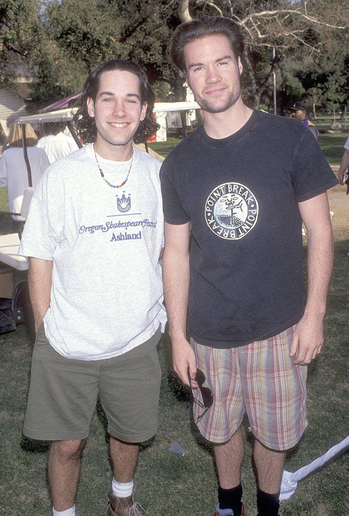 Paul wearing a t-shirt and shorts as he stands next to a man for a photo