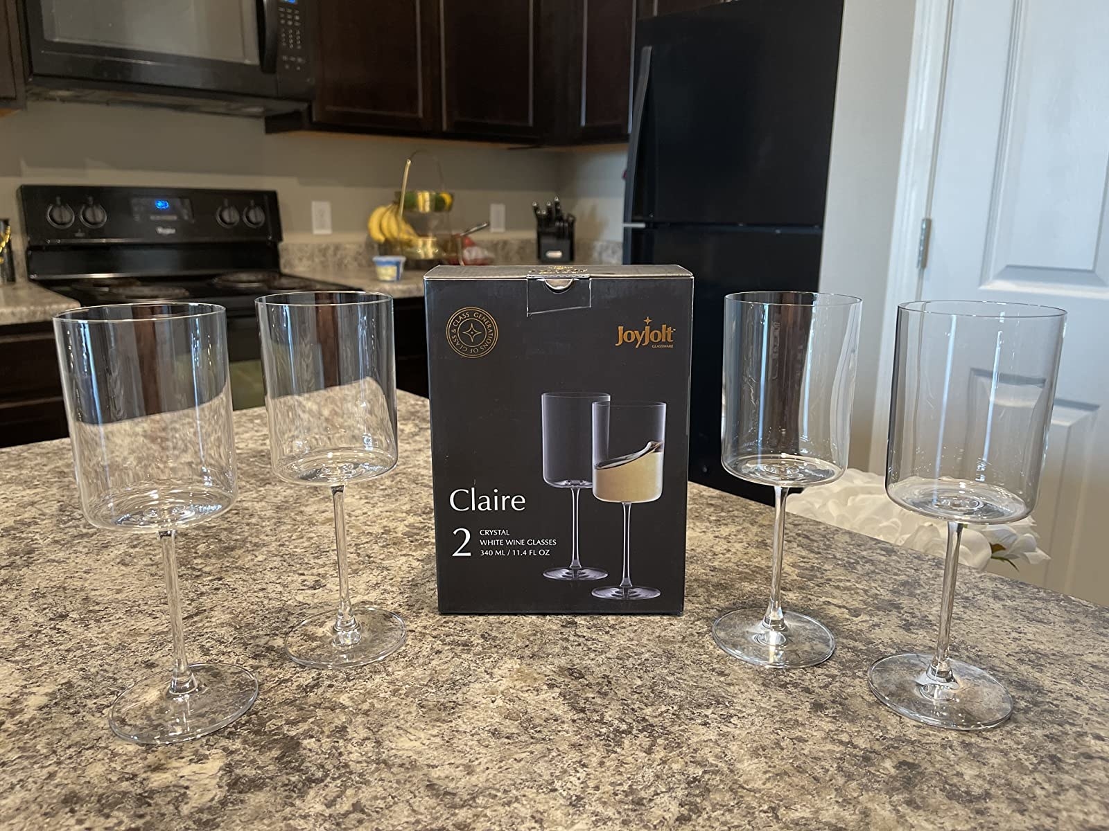 four of the wine glasses set out on a countertop with the box in the middle