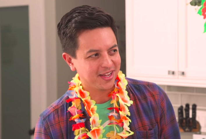 Brandon as an adult wearing flowers around his neck