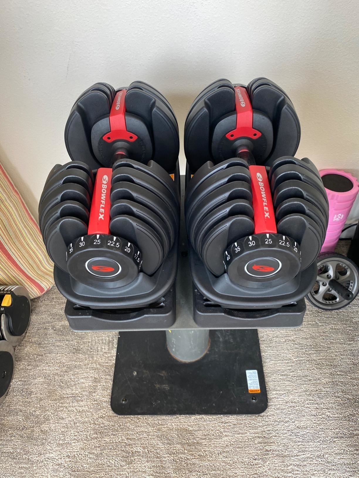 t6he set of adjustable dumbbells in their holding stand