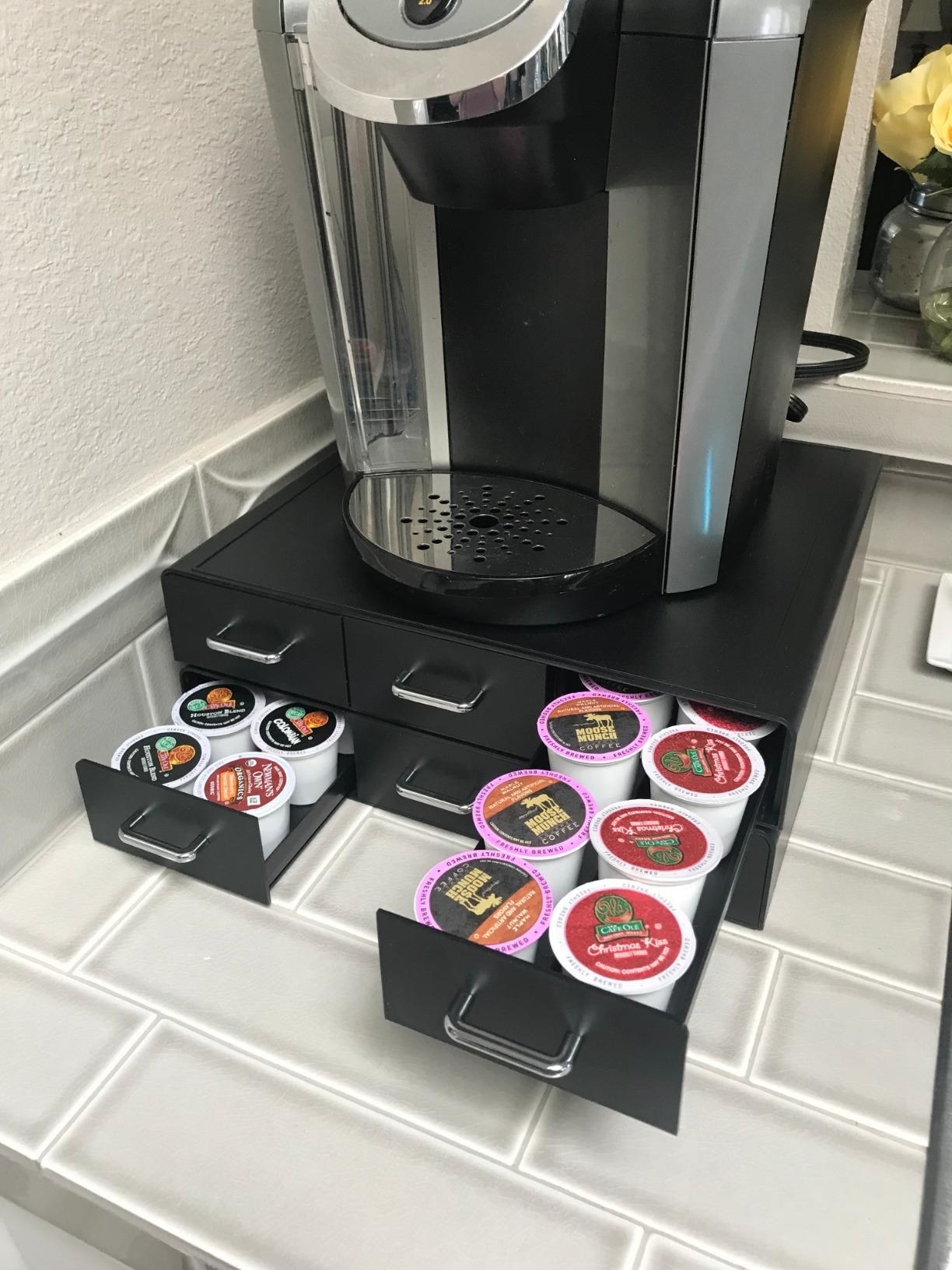 reviewer image of a keurig on top of the drawers with two drawers open showing the coffee pods inside