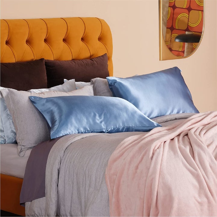 The blue satin cases on pillows on a bed