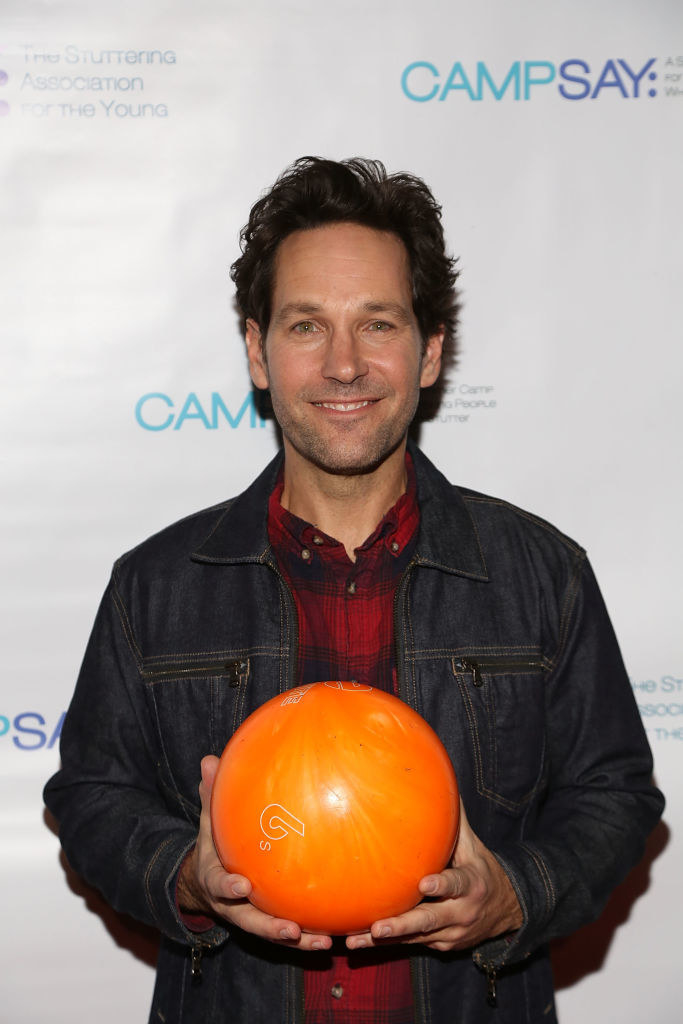 Paul on a red carpet holding a bowling ball