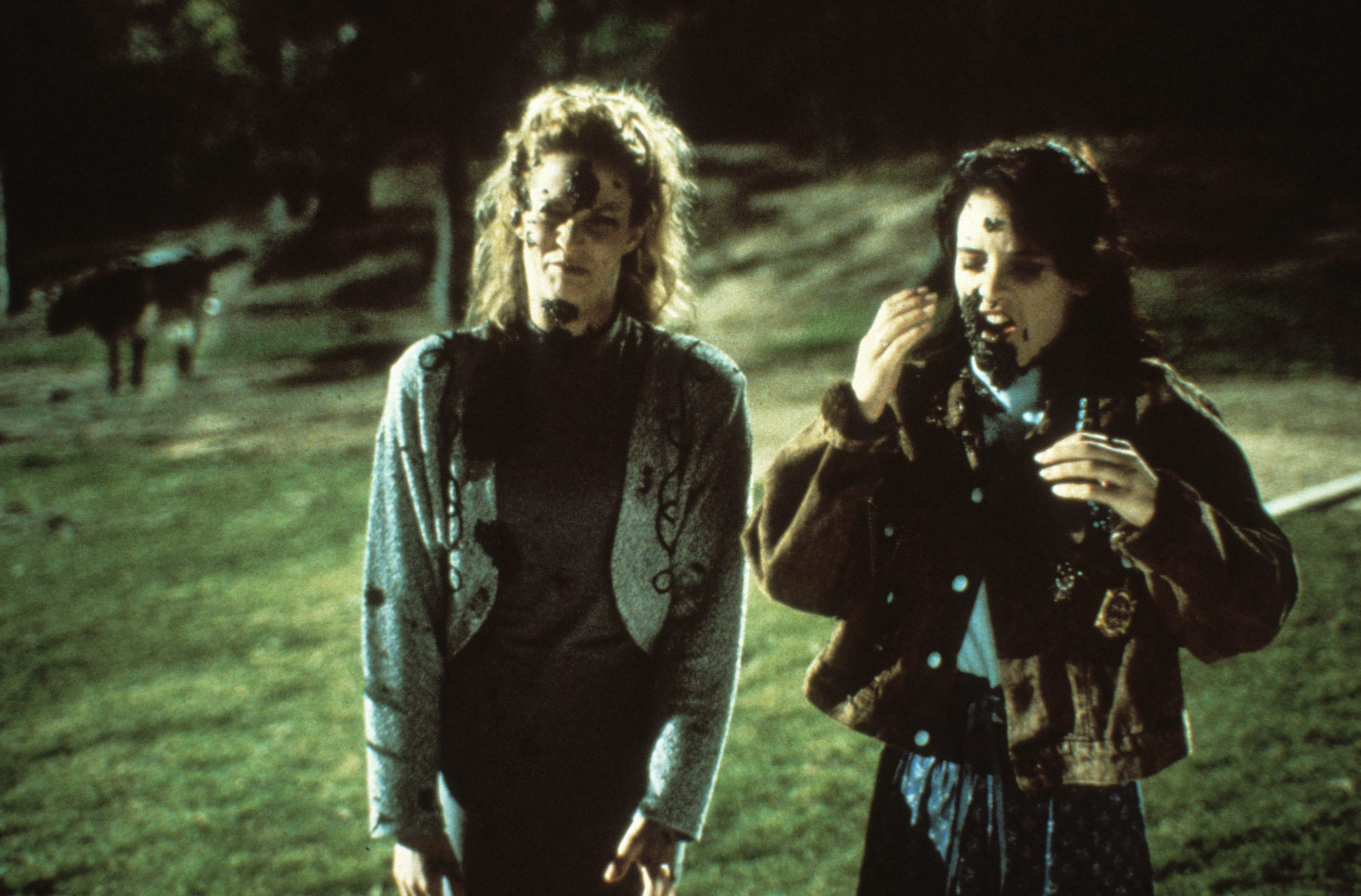 Falk and Winona Ryder in a scene in a field, covered in muck