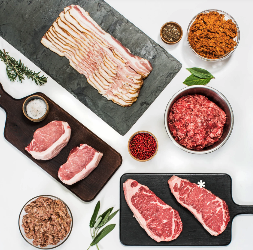 different raw cuts and types of meats styled out on a table