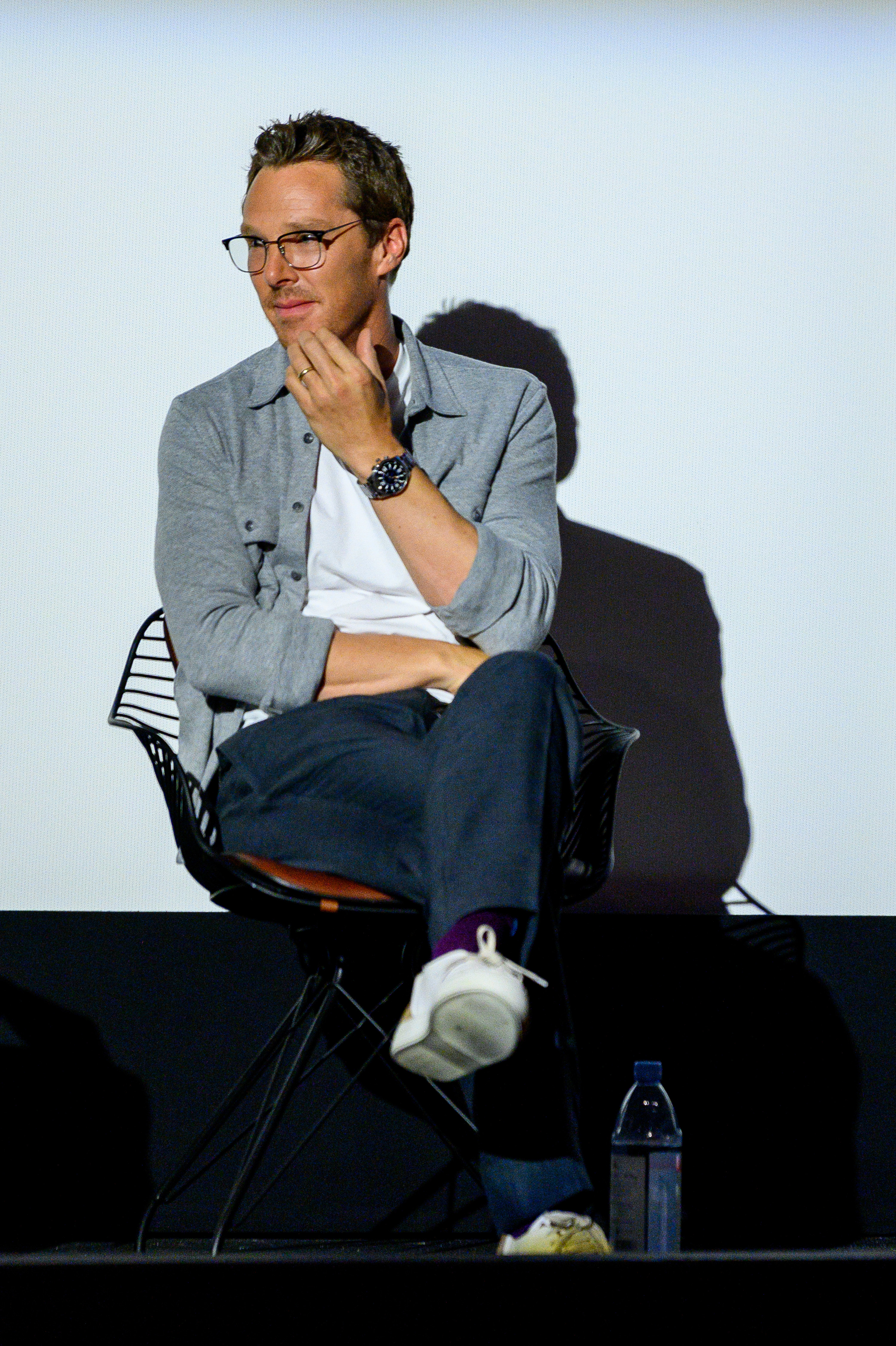 Cumberbatch sits with his legs crossed during a panel