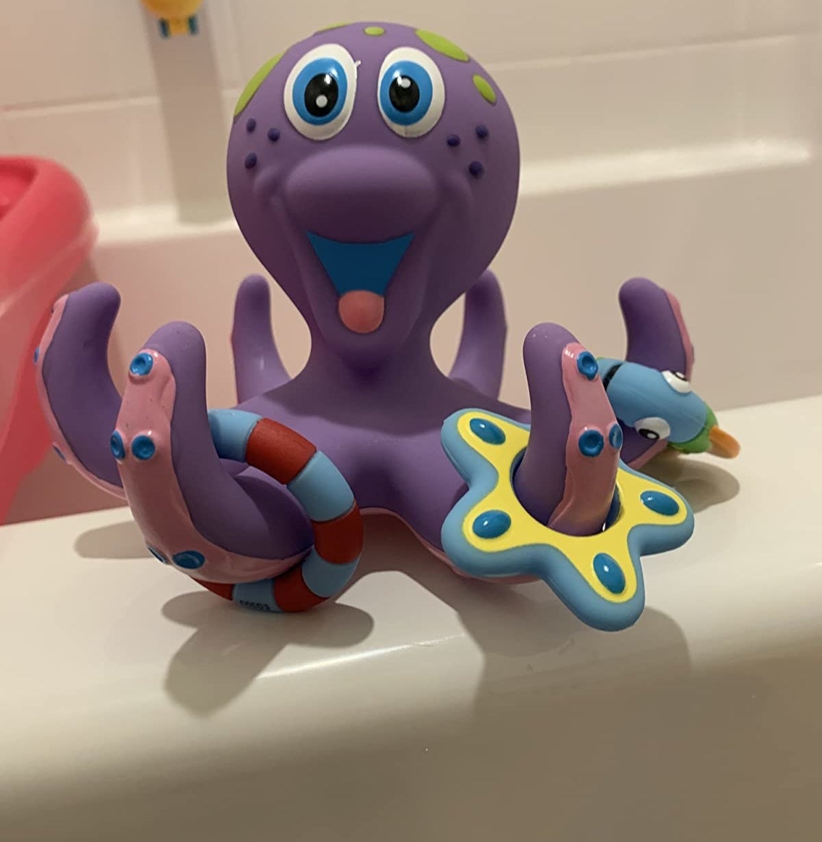 Reviewer&#x27;s photo of purple plastic octopus with colorful rings on its tentacles