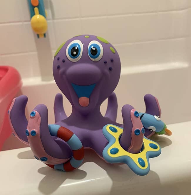Reviewer's photo of purple plastic octopus with colorful rings on its tentacles