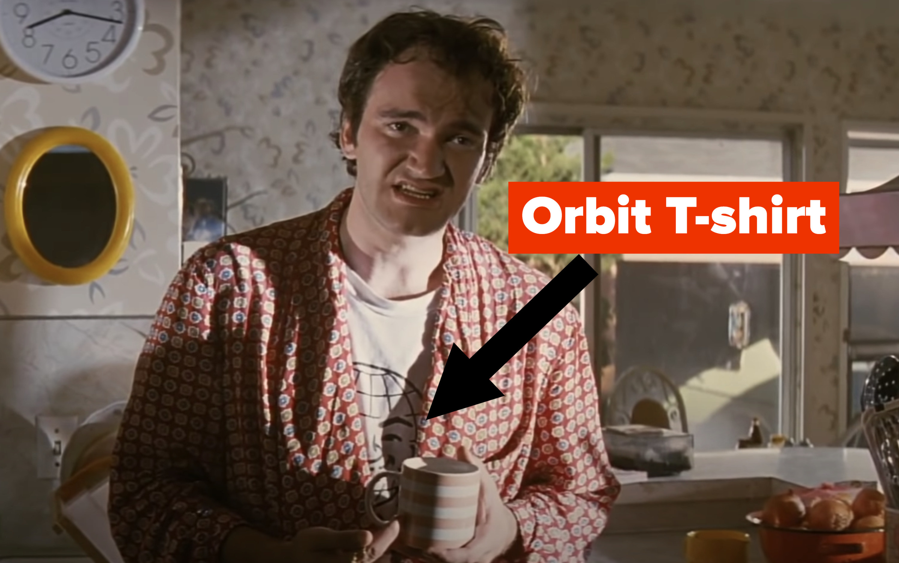 Tarantino in the film with an arrow pointing out his Orbit T-shirt