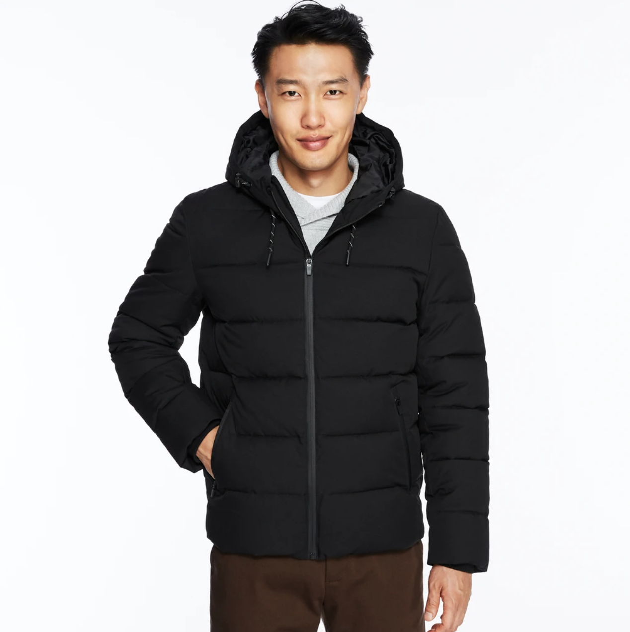 a smiling person wearing a short puffer jacket while looking into the camera