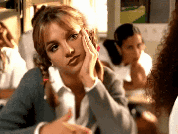 Gif of Britney Spears looking bored in the Baby One More Time music video