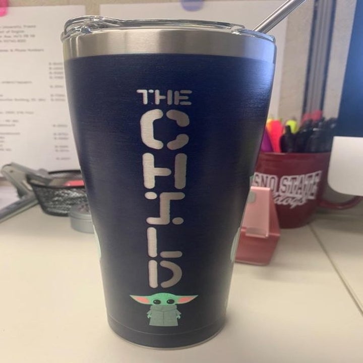 the back of the tumbler that says "the child" going down and a small picture of baby yoda