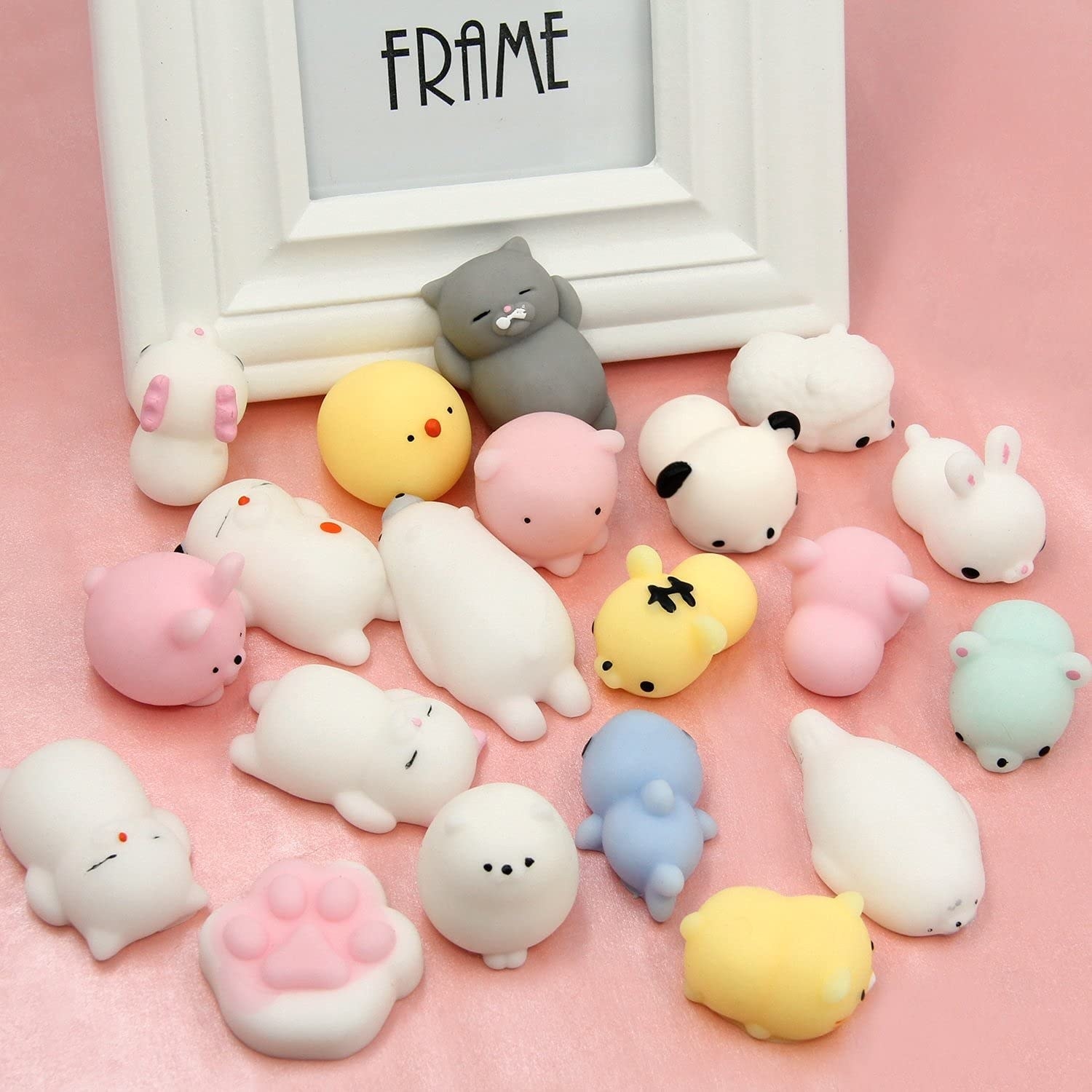 A bunch of tiny silicone animals next to a picture frame