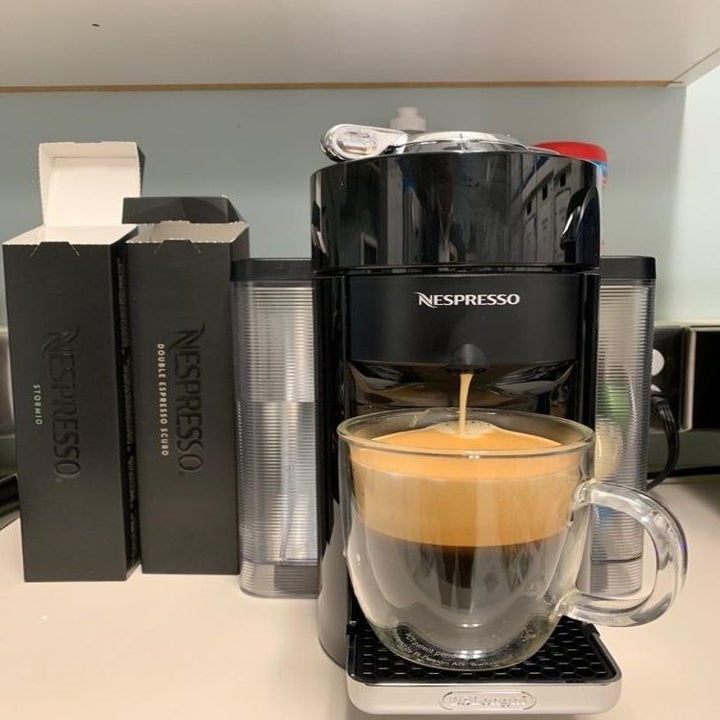 reviewer using the coffee machine to make frothed coffee