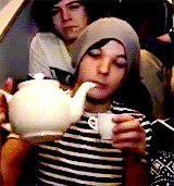 Louis Tomlinson pouring tea from a white tea pot to a white tea cup. A clip from the Video Diaires