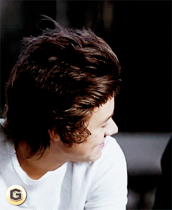 Harry blushing, smiling and looking into the camera