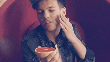 Louis rubbing a grapefruit on his face