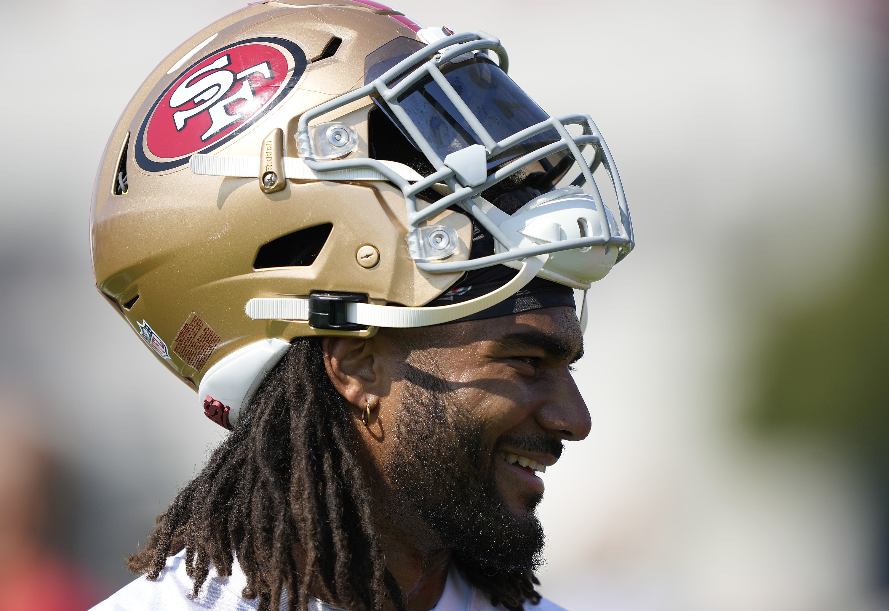 Fred Warner with his 49ers helmet lifted to show his face