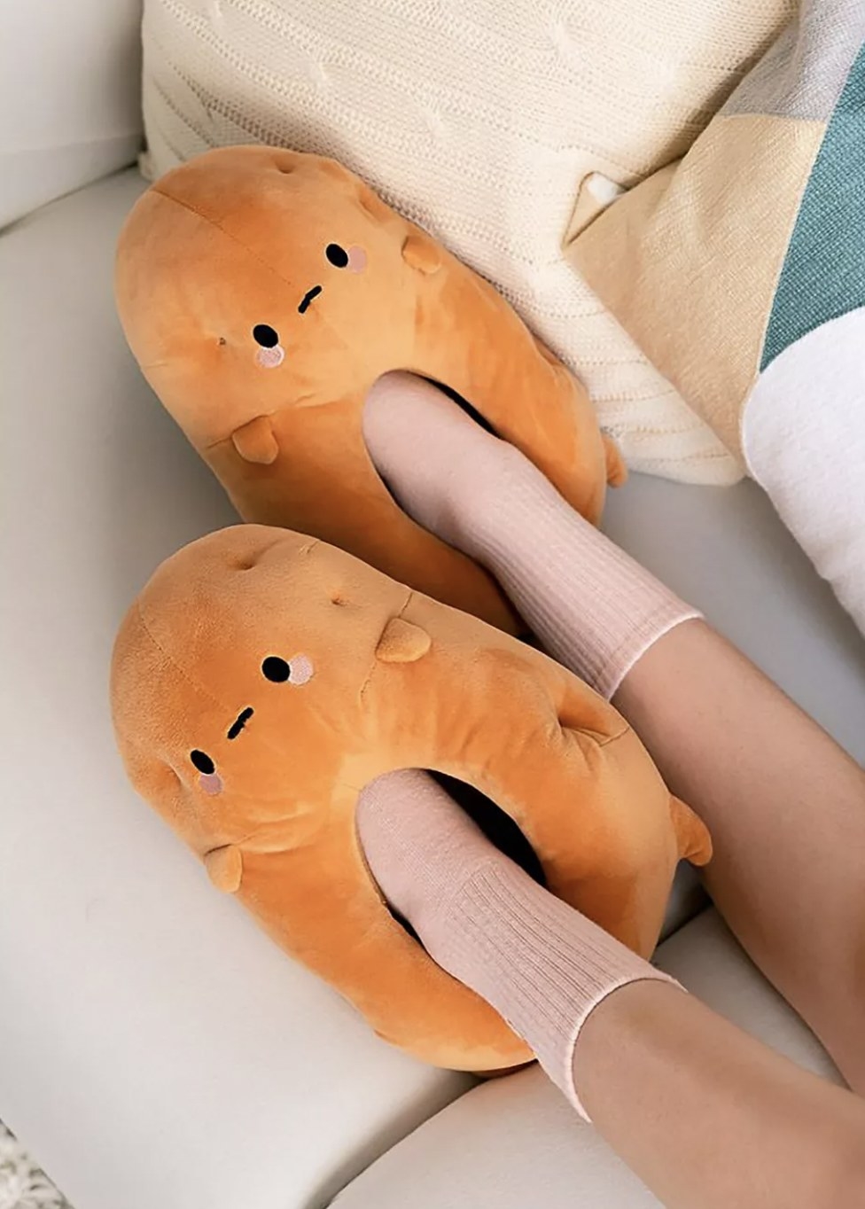 a pair of orange potato slippers on a person