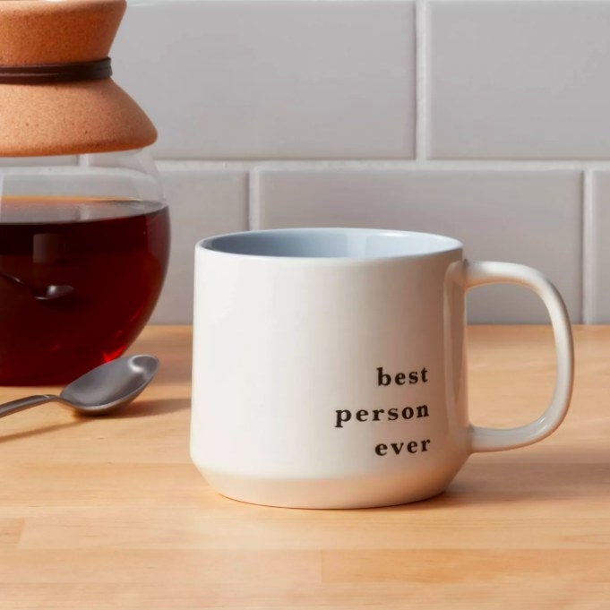 The white mug with black text that says "best person ever"