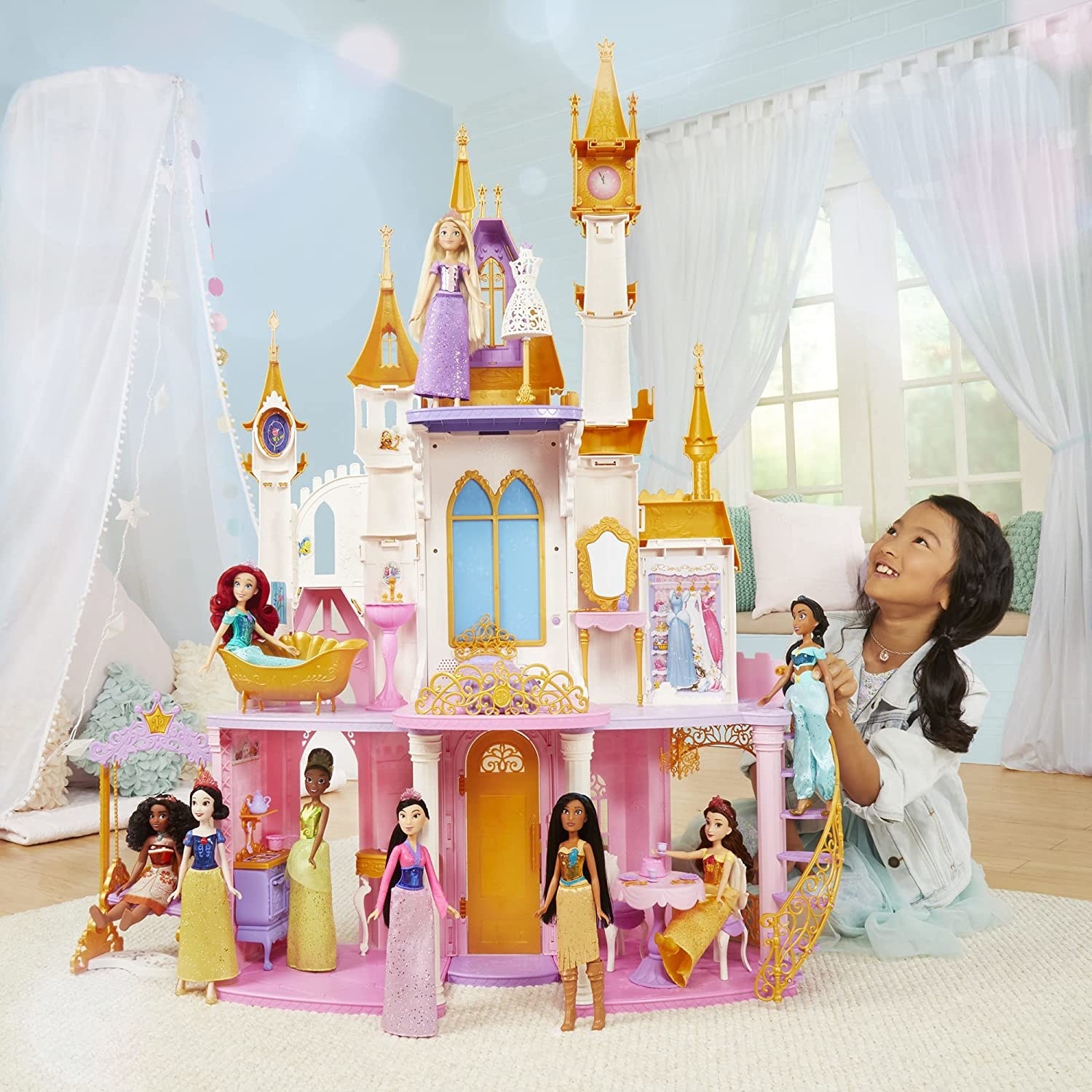 A person playing with Disney dolls in the house