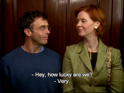 Steve and Miranda look at each other as they stand in an elevator