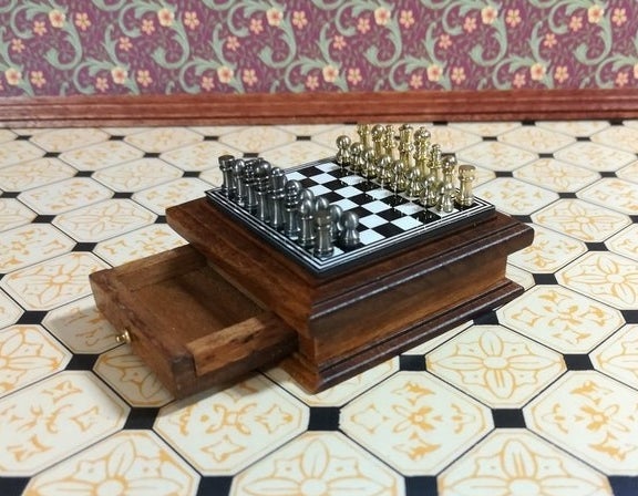 Mini wooden chess set with silver and gold pieces and storage drawer