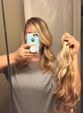 a reviewer holding the blonde extensions