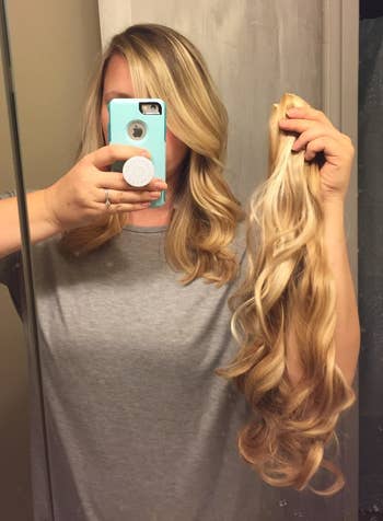 a reviewer holding the blonde extensions