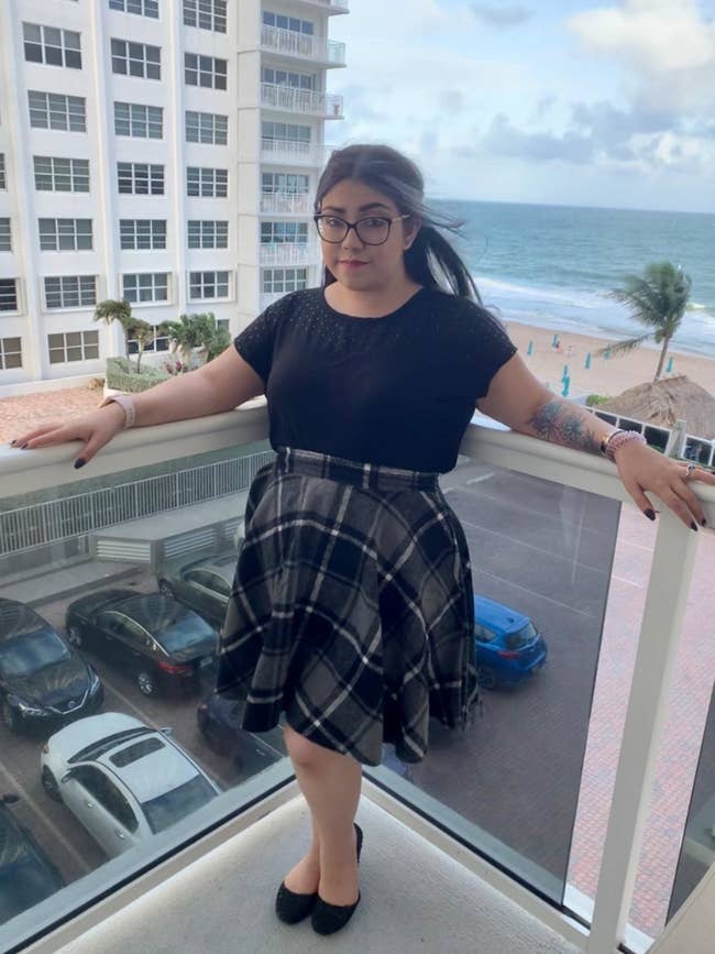reviewer wearing gray plaid skirt
