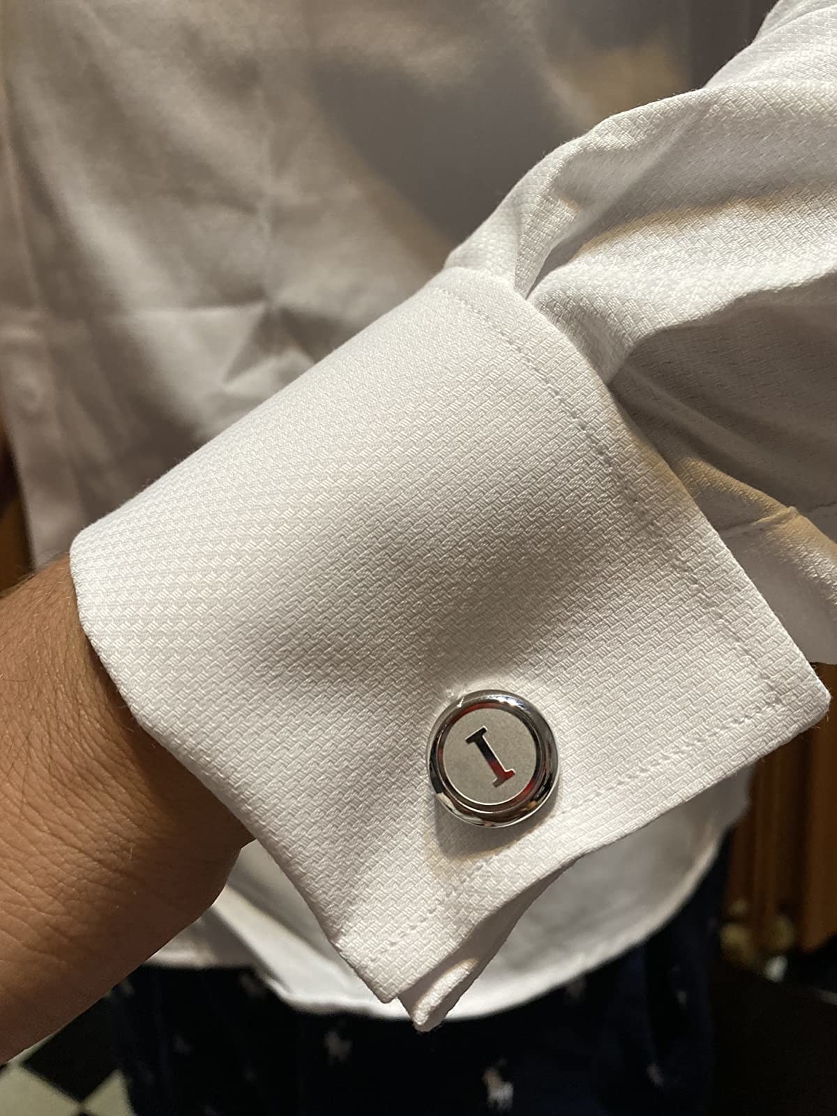 The round silver letter I initial cufflinks on a shirt cuff