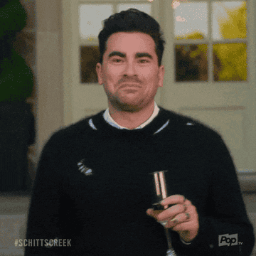 a gif of David in &quot;Schitt&#x27;s Creek&quot; holding a champagne flute, crying, and saying &quot;It&#x27;s perfect&quot;