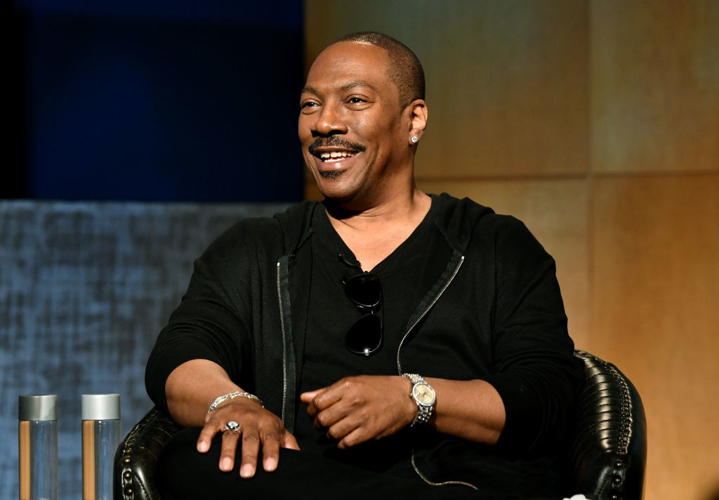 Eddie Murphy sitting and speaking to an audience at an event