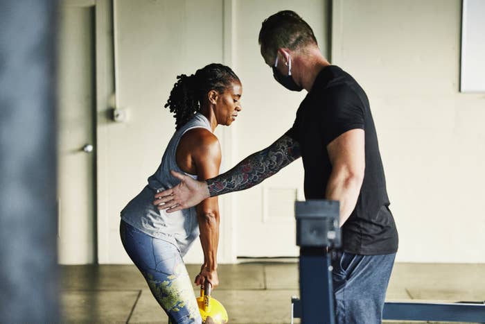 A trainer leading a woman in the gym