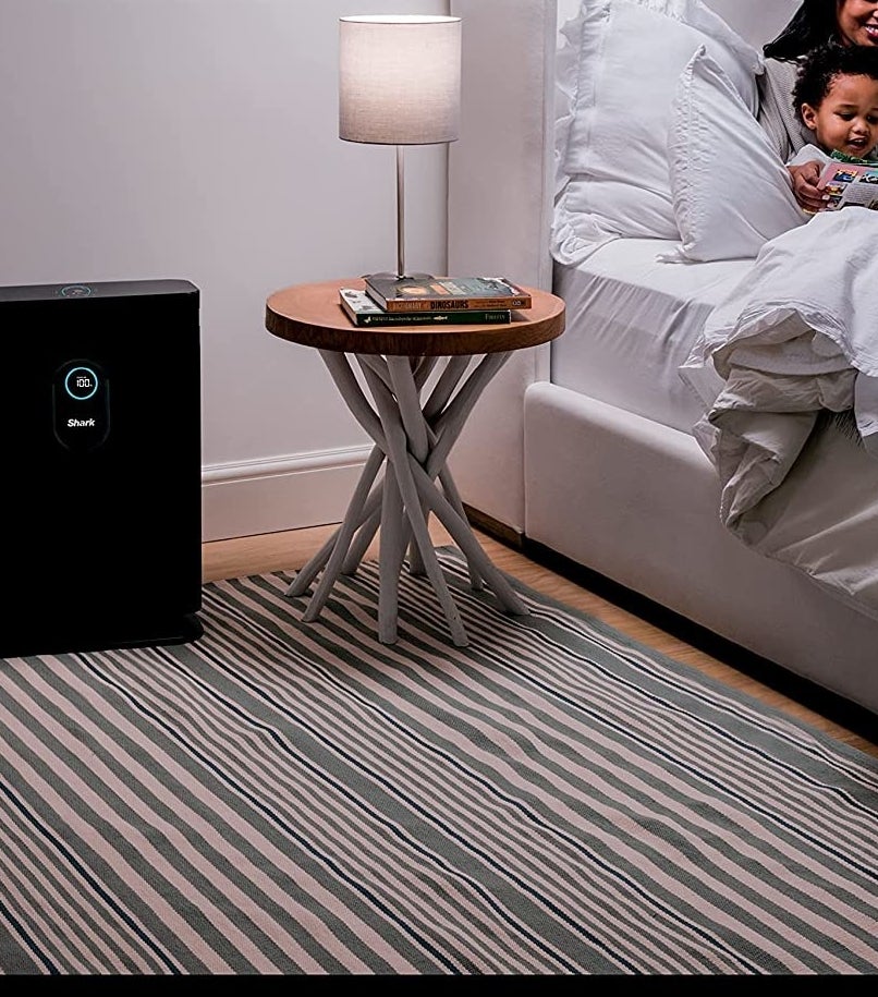 The air purifier next to a bedside table