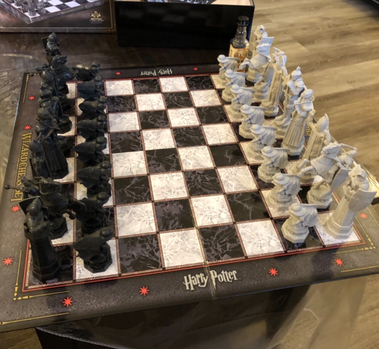 Reviewer image of black and white cardboard chessboard that says &quot;Harry Potter wizard chess set&quot; with pieces set up
