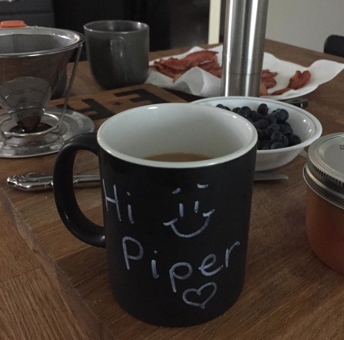 Reviewer photo of the chalkboard mug on a breakfast table with the words "Hi Piper" written on it