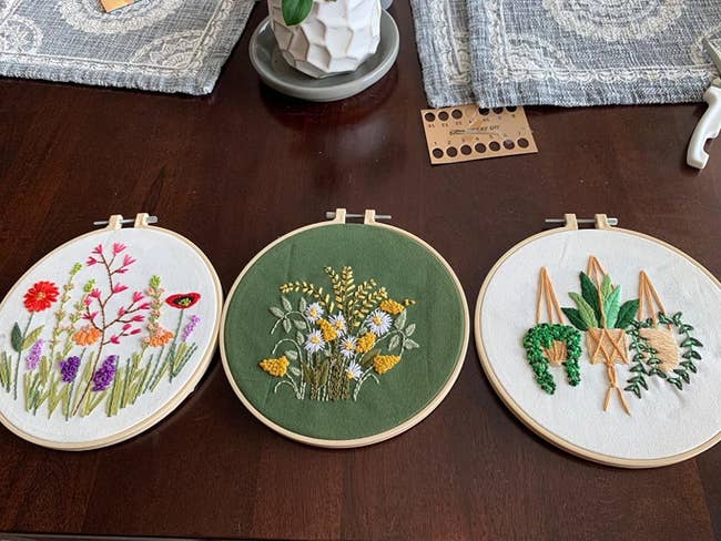 A reviewer's three completed embroideries, which are all plant/flower themed