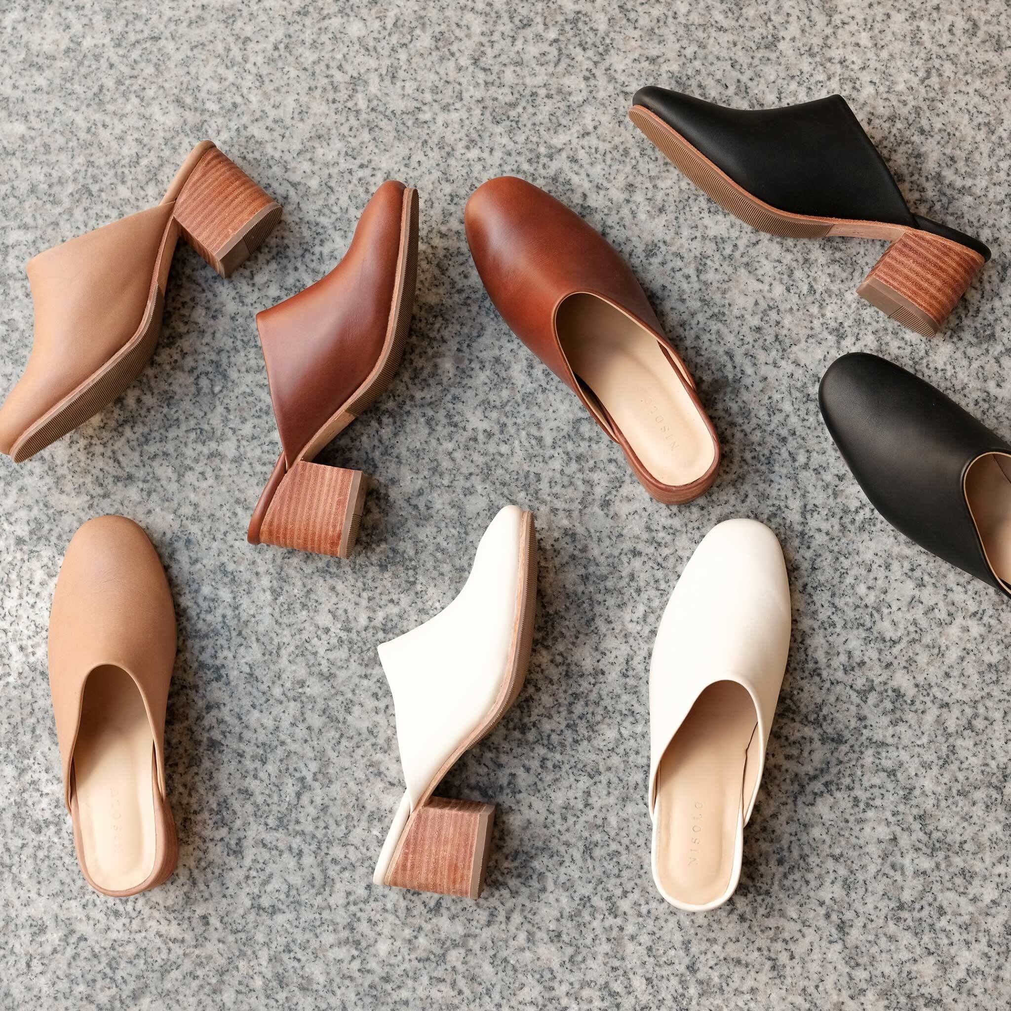 several pairs of the same mule in different colors on the floor
