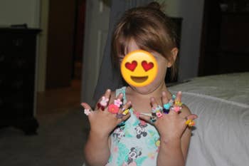 Reviewer's photo of a child wearing all 24 rings on their fingers