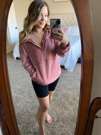 a reviewer in a pink half-zip pull over