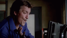 rick castle from &quot;castle&quot; looking at his computer and saying &quot;booyah&quot;