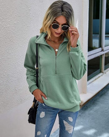 a model in a sage green half zip