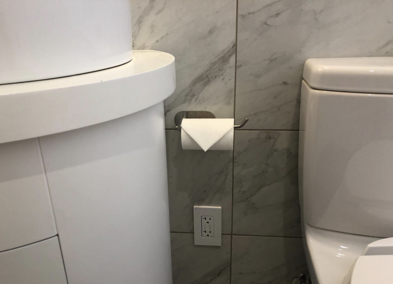 A reviewer&#x27;s toilet paper holder on the wall