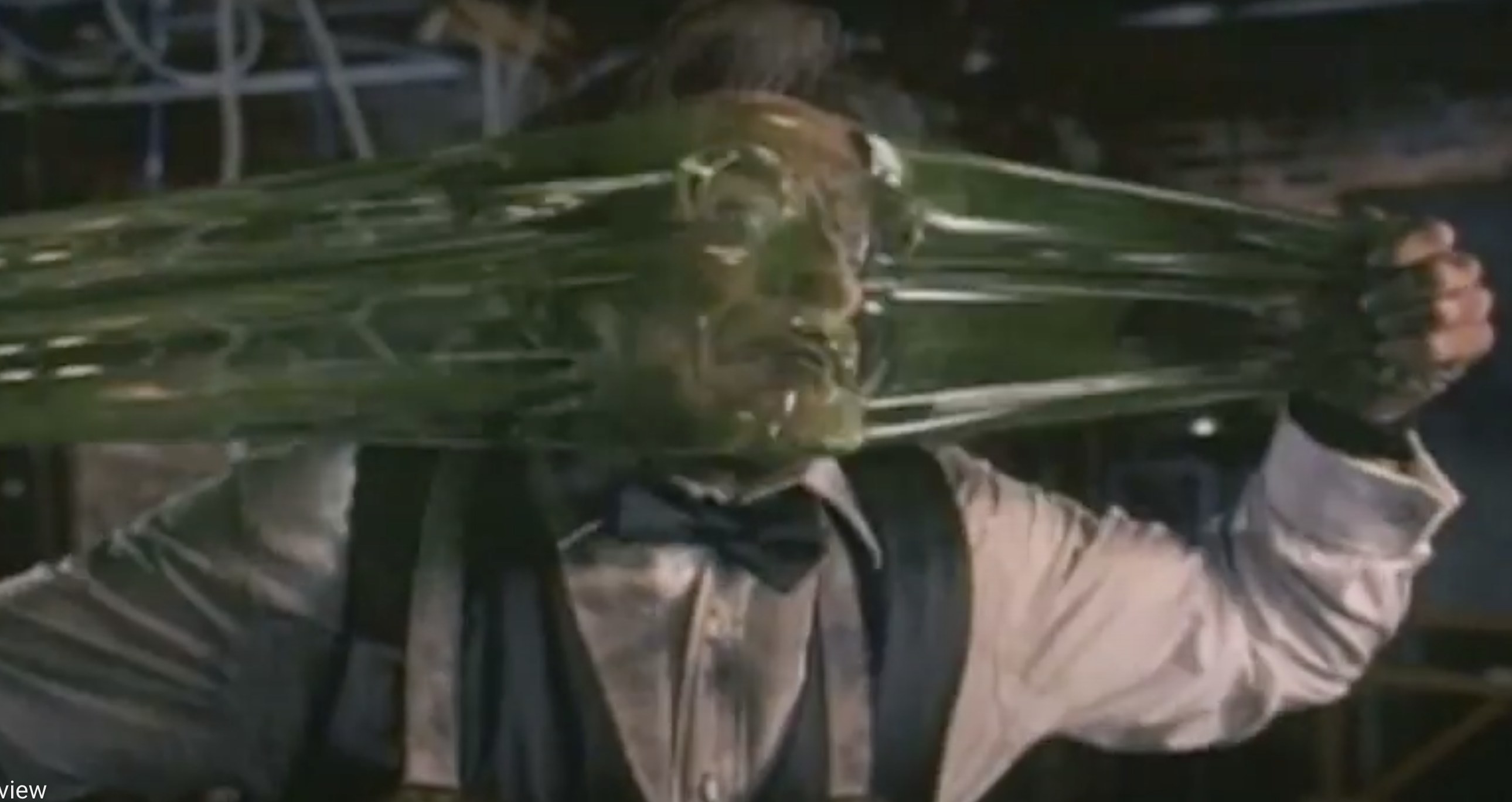 Actor Robin Williams stretches a green transparent slime across his face.