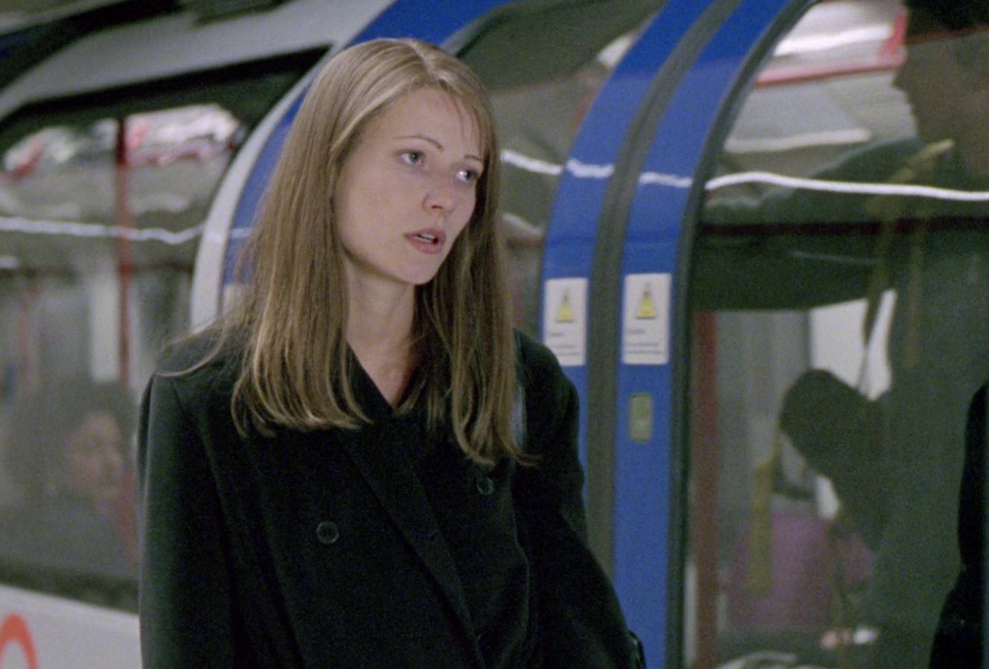 Gwyneth Paltrow stands outside of a subway and looks very upset.