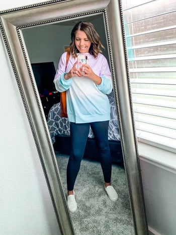 a reviewer in a color blocked pink, blue, and white sweatshirt