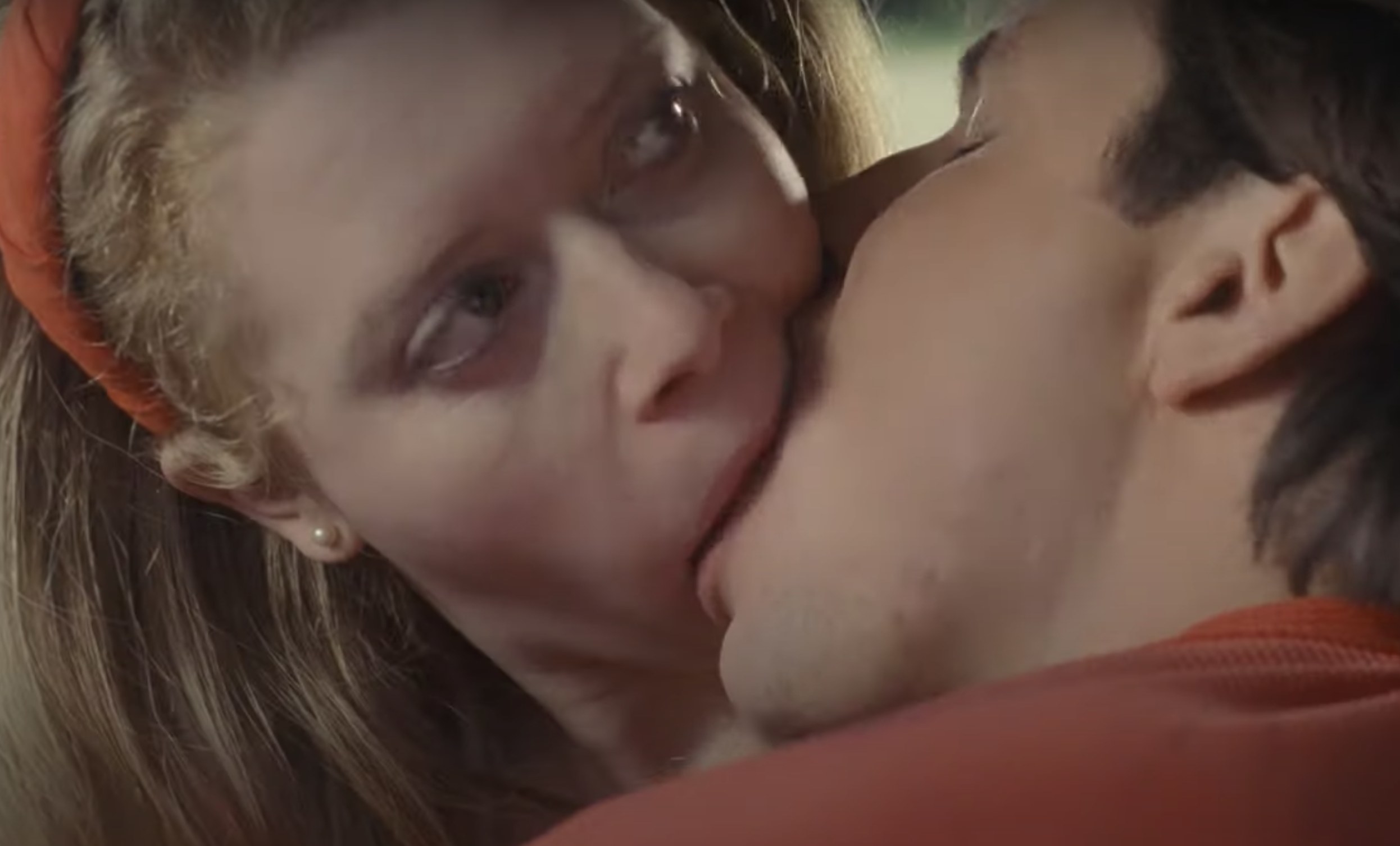 Actor Natasha Lyonne has her eyes wide open and looks uncertainly as she makes out with a boy.