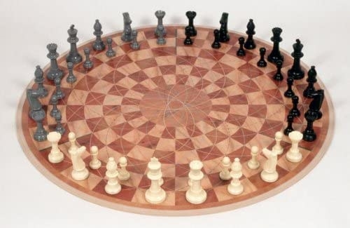 Brown circle chess board with white, gray, and black chess pieces set up
